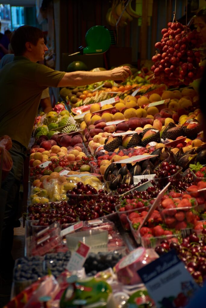 A man standing in front of a display of fruit