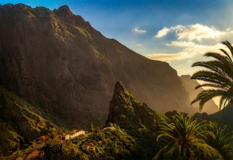 Majestic landscape of Masca Valley in Tenerife, Spain with rocky mountains and vibrant greenery at sunset.