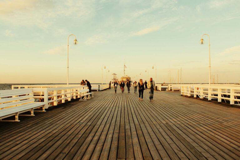 People walking along the Sopot Pier during sunset, capturing a serene seaside moment in Poland.